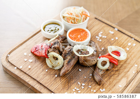 Lamb tongue kebab with Pickled cabbage and two sauces. Serving on a wooden Board. Barbecue 58586387