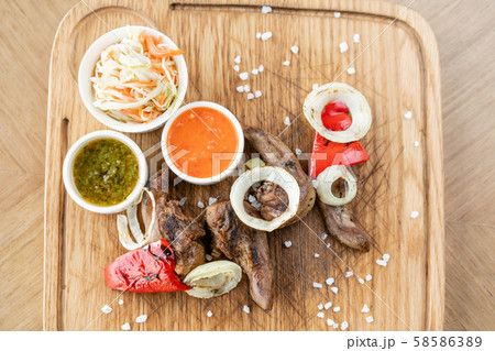 Lamb tongue kebab with Pickled cabbage and two sauces. Serving on a wooden Board. Barbecue Lamb tongue kebab with Pickled cabbage and two sauces. Serving on a wooden Board. Barbecue 58586389