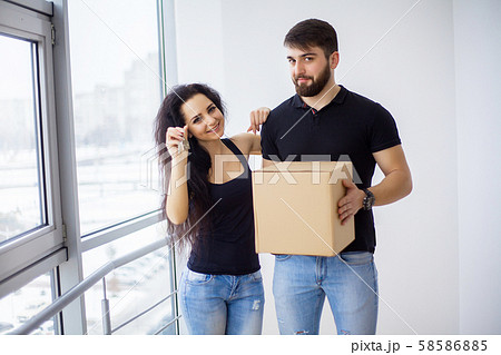 Couple showing keys to new home hugging looking at camera 58586885