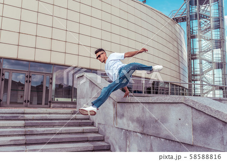 Dancer jumping jump dancing break dance, hip hop. Summer city, background building. Active youth Dancer jumping jump dancing break dance, hip hop. Summer city, background building. Active youth 58588816