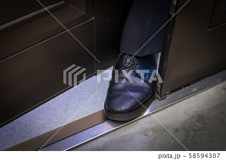 玄関に足を挟み込んでくるスーツの男 玄関に足を挟み込んでくるスーツの男 58594307