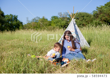 Mom and son eat in park picnic in nature family Mom and son eat in park picnic in nature family 58594473