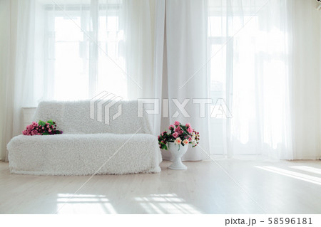white sofa with flowers stands alone in the white room white sofa with flowers stands alone in the white room 58596181