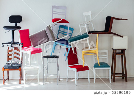 many different chairs stand in the white room 58596199