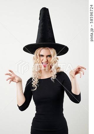 Studio portrait of woman in witch Halloween costume 58596724