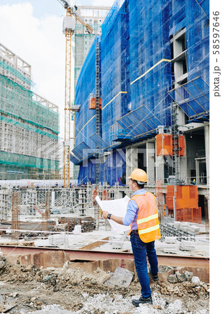 Engineer checking building blueprint Engineer checking building blueprint 58597646