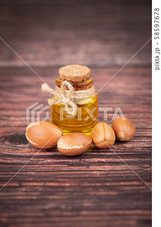 Argan oil, on wooden background. Argan nuts and seeds, for cosmetic and beauty products. Natural Argan oil, on wooden background. Argan nuts and seeds, for cosmetic and beauty products. Natural 58597678