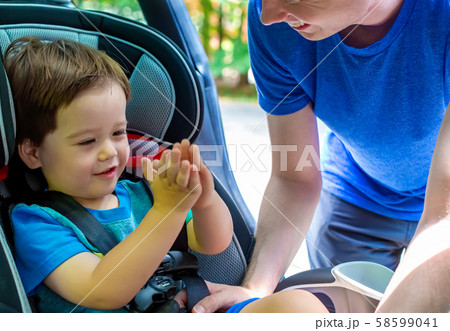 Toddler boy buckled into his car seat Toddler boy buckled into his car seat 58599041