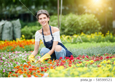 Pretty woman working with plans and flowers Pretty woman working with plans and flowers 58599521