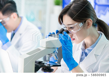 Asian scientist use microscope 58600965