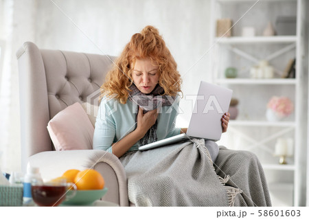 Young sick woman coughing after catching seasonal cold Young sick woman coughing after catching seasonal cold 58601603