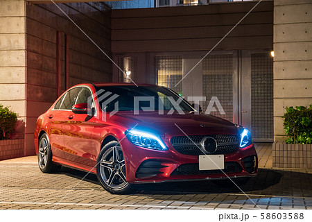 ワインレッドの車とマンションの夜景の写真素材