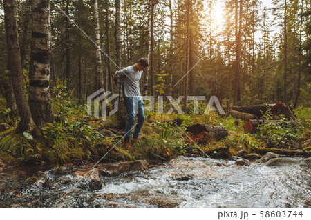 young man taking off clothes while standing on the bank of the river young man taking off clothes while standing on the bank of the river 58603744