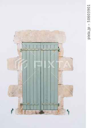 Old window with wooden light green painted shutters Old window with wooden light green painted shutters 58603901