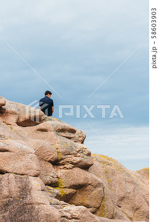 Young man on top of rock formations in Brittany 58603903