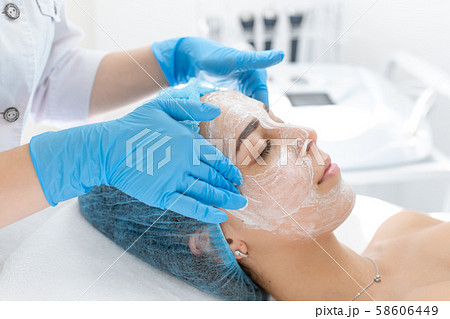 Woman professional doctor beautician applies a 58606449