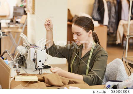 Woman sewing at the table 58606808
