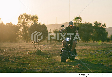 man on a motorized bicycle in sunset time man on a motorized bicycle in sunset time 58607952