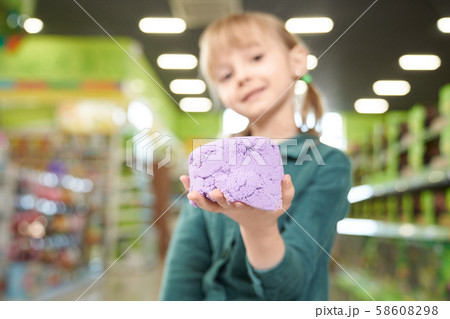 Close up of kinetic sand on hand of child. Close up of kinetic sand on hand of child. 58608298