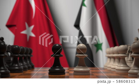 Flags of Turkey and Syria behind pawns on the chessboard. Chess game or political rivalry related 3D Flags of Turkey and Syria behind pawns on the chessboard. Chess game or political rivalry related 3D 58608315