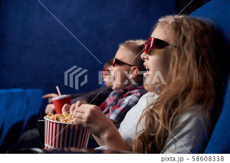 Shocked girl with friends watching film in movie house Shocked girl with friends watching film in movie house 58608338