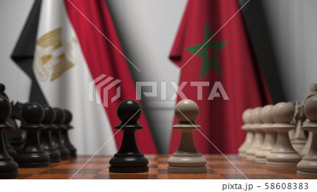 Flags of Egypt and Morocco behind pawns on the chessboard. Chess game or political rivalry related 58608383