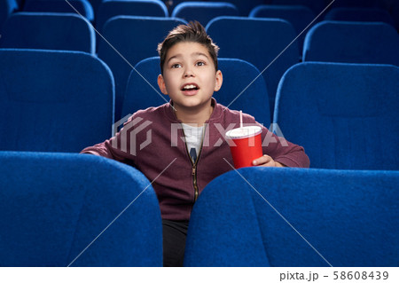 Delighted boy watching interesting film in cinema 58608439