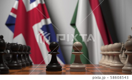 Flags of Great Britain and Hungary behind pawns on the chessboard. Chess game or political rivalry 58608543