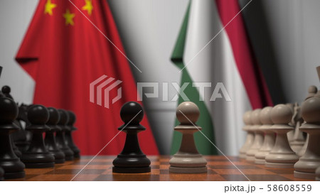 Flags of China and Hungary behind pawns on the chessboard. Chess game or political rivalry related 58608559