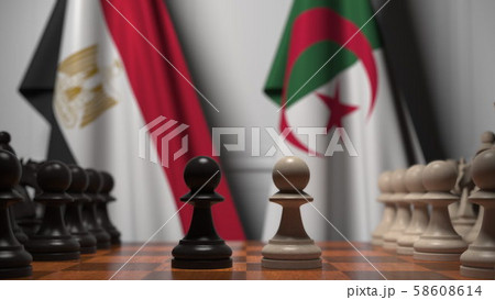 Flags of Egypt and Algeria behind pawns on the chessboard. Chess game or political rivalry related Flags of Egypt and Algeria behind pawns on the chessboard. Chess game or political rivalry related 58608614