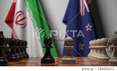 Flags of Iran and New Zealand behind pawns on the chessboard. Chess game or political rivalry 58608823