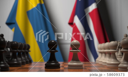Flags of Sweden and Norway behind pawns on the chessboard. Chess game or political rivalry related 58609373