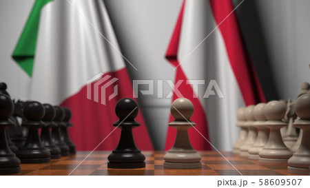 Flags of Italy and Austria behind pawns on the chessboard. Chess game or political rivalry related 58609507