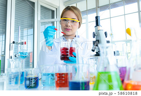 Young female doing experiments and researchers 58610818