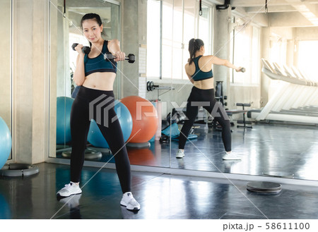 Sporty fit woman workout exercises with dumbbells. Sporty fit woman workout exercises with dumbbells. 58611100
