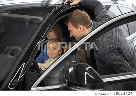 Man looking at salon while wife sitting on seat of driver 58613424