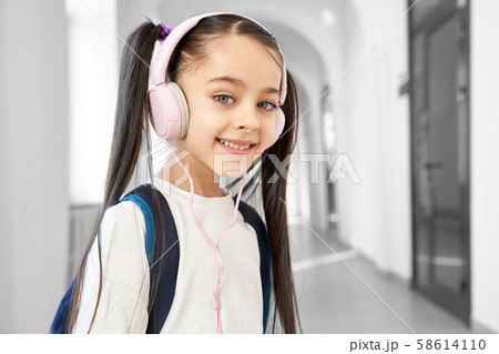 Pretty schoolgirl with headphones posing in hallway. Pretty schoolgirl with headphones posing in hallway. 58614110
