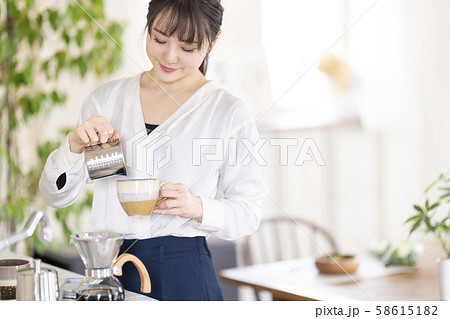 エスプレッソとミルクが絡み合う芳醇な味わいのカフェラテを自宅で淹れて楽しむ女性 エスプレッソとミルクが絡み合う芳醇な味わいのカフェラテを自宅で淹れて楽しむ女性 58615182