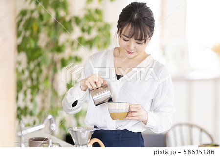 ミルクのようになめらかで優しい甘さのカプチーノを自宅で淹れて楽しむ女性 ミルクのようになめらかで優しい甘さのカプチーノを自宅で淹れて楽しむ女性 58615186