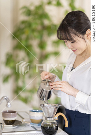 ドリップポットからドリッパーにお湯を注ぎゆっくりとモーニングコーヒーを楽しむ女性ライフスタイル ドリップポットからドリッパーにお湯を注ぎゆっくりとモーニングコーヒーを楽しむ女性ライフスタイル 58615190