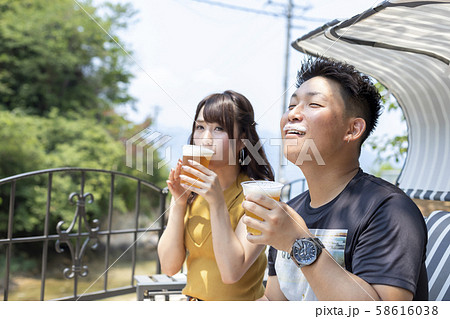 別荘の庭でビールを飲むカップル 58616038
