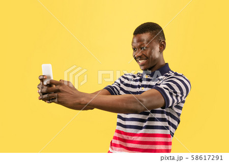 Young african-american man isolated on yellow studio background, human emotions concept. 58617291