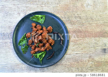 spicy fried chicken tendon with chili and lemon leaf on dish spicy fried chicken tendon with chili and lemon leaf on dish 58618681