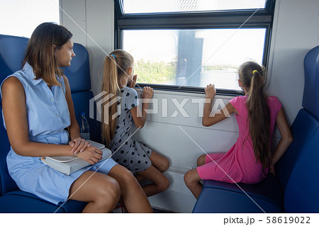 Mom and two daughters ride in an electric train, Mom and two daughters ride in an electric train, 58619022