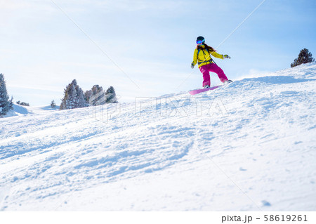 Sportive woman in helmet snowboarding at winter resort . Sportive woman in helmet snowboarding at winter resort . 58619261