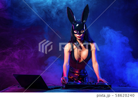 Young sexy woman dj playing music. Headphones and dj mixer on table. Young sexy woman dj playing music. Headphones and dj mixer on table. 58620240