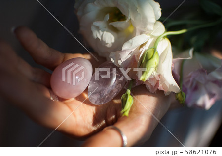Female hands holding two yoni eggs for vumfit, imbuilding or meditation are made from pink quartz Female hands holding two yoni eggs for vumfit, imbuilding or meditation are made from pink quartz 58621076