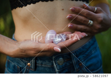 Female hands holding two yoni eggs for vumfit, imbuilding or meditation are made from pink quartz Female hands holding two yoni eggs for vumfit, imbuilding or meditation are made from pink quartz 58621097