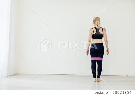 Female athlete squats with fitness gum sports 58621354