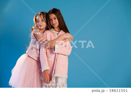Two girls girlfriend in pink clothes cuddle laughing Two girls girlfriend in pink clothes cuddle laughing 58621501